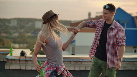 Loving-couple-in-red-plaid-shirts-dance-on-the-roof.-Girl-with-beer-spinning-in-dance-with-her-russian-boyfriend.